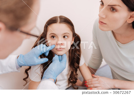 Focused prominent dermatologist examining little Focused prominent dermatologist examining little 30672267