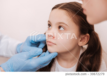 Nice sad child visiting dermatologist with her mom Nice sad child visiting dermatologist with her mom 30672279