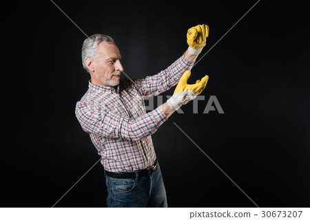 Attentive man wearing rubber gloves 30673207