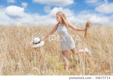 Happy Young woman in a wheat field 30673714