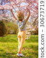 Beautiful happy young woman in a flowering spring garden 30673719