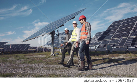 Technician walks with workman and investor Technician walks with workman and investor 30675087