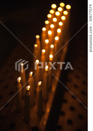 Burning prayer candles stand in a row Burning prayer candles stand in a row 30677074