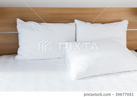 White pillows lay on wide empty bed 30677081