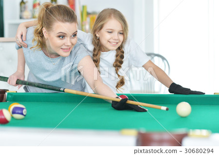 Mother with her daughter playing pool 30680294