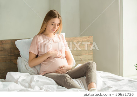 Young preganant woman expecting a baby relaxing on 30681726