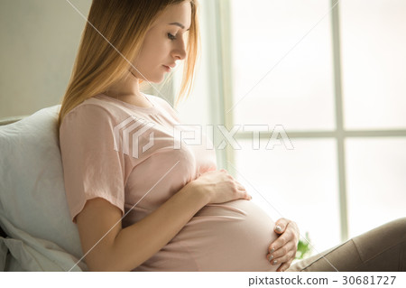 Young preganant woman expecting a baby relaxing on 30681727