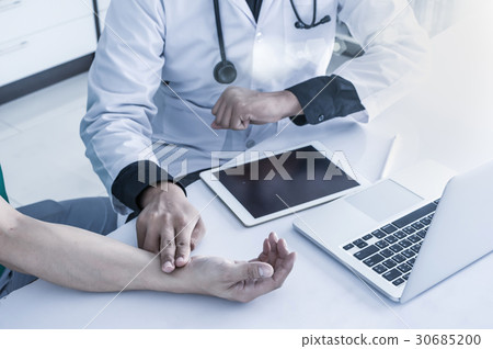Doctor is consulting with Patient about his health on working desk which using technology tablet at hospital, physician concept Doctor is consulting with Patient about his health on working desk which using technology tablet at hospital, physician concept 30685200
