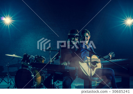 Musician duo band singing a song and playing music instrument with Fellow band musicians on black background with spot light and lens flare, musical concept 30685241