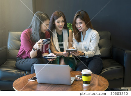 Group Of Asian Businesswomen with casual suit brainstorm Meeting with looking at tablet In the coffee shop, business technology concept Group Of Asian Businesswomen with casual suit brainstorm Meeting with looking at tablet In the coffee shop, business technology concept 30685250