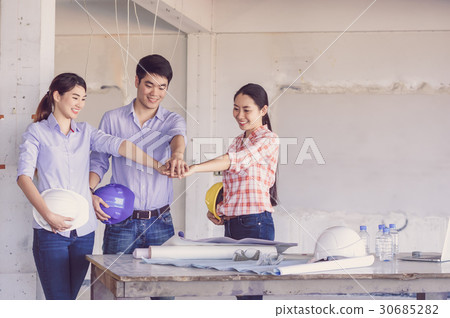 Teamwork Stacking Hand of Corporate Colleagues between professional construction engineers before project start at the building site, Industrial engineering and teamworks Concept Teamwork Stacking Hand of Corporate Colleagues between professional construction engineers before project start at the building site, Industrial engineering and teamworks Concept 30685282