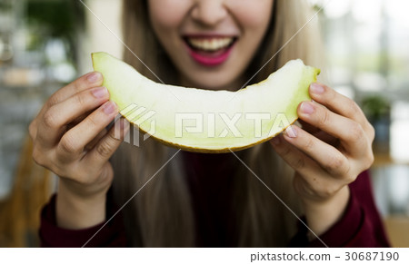 Woman eating melon honeydew with happiness smile 30687190