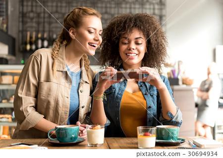 Smiling women watching at mobile 30694934