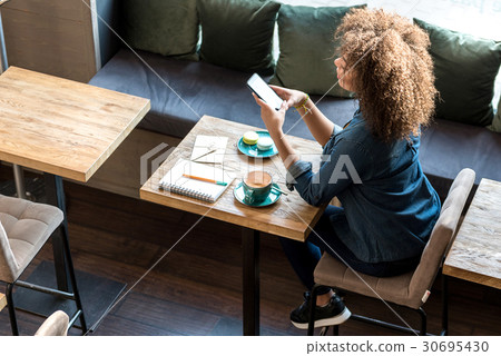 Thoughtful female watching at cellphone Thoughtful female watching at cellphone 30695430