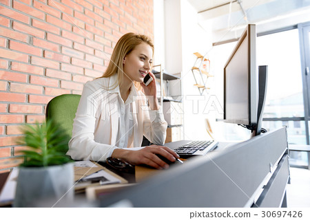 Charming girl sitting on her workplace with smile Charming girl sitting on her workplace with smile 30697426