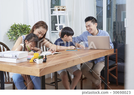 parents help their children doing homework carefully 30698023