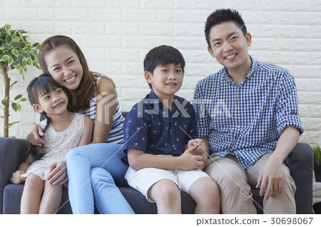 A happy young family is smiling on sofa in free time 30698067