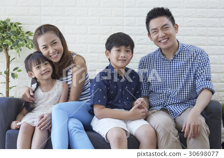 A happy young family enjoys their free time on sofa 30698077
