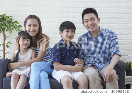 a happy family is resting on the sofa. a happy family is resting on the sofa. 30698138
