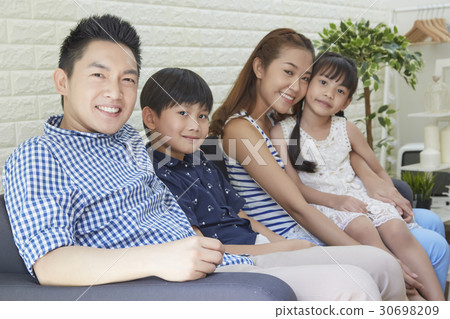 The happy family is sitting on the sofa at home. The happy family is sitting on the sofa at home. 30698209