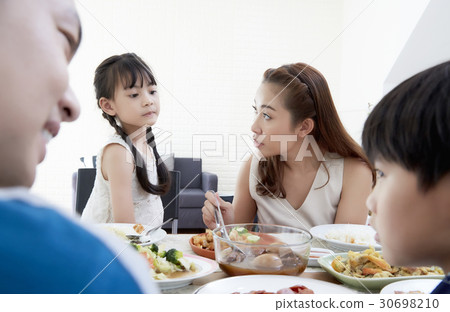 Mother, daughter and others are talking while eating a meal together. Mother, daughter and others are talking while eating a meal together. 30698210