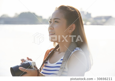 Beautiful girl is holding the camera and sightseeing. 30698211