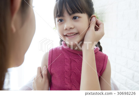 Mother is touching the face of the little daughter. 30698226