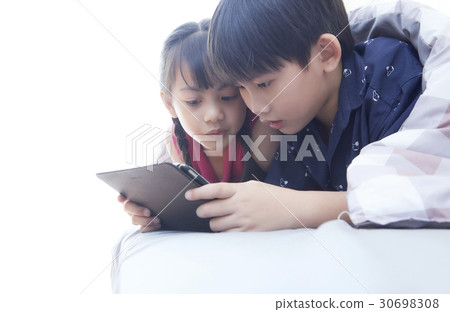a photo of two kids watching an ipad 30698308