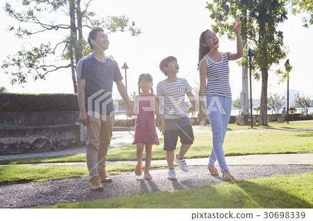 a family of four people is sightseeing and looking at something. a family of four people is sightseeing and looking at something. 30698339
