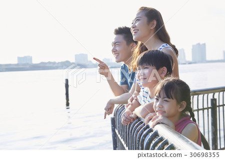 A couple and two children are smiling and viewing on a riverside. A couple and two children are smiling and viewing on a riverside. 30698355