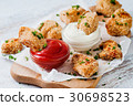 Fried nuggets dipped into two sauces 30698523