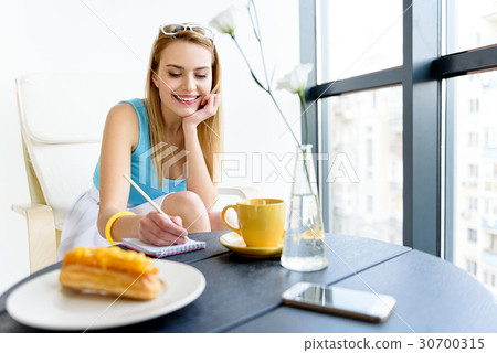 Cheerful girl writing with smile 30700315
