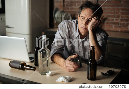 Portrait of upset man while holding empty glass Portrait of upset man while holding empty glass 30702978