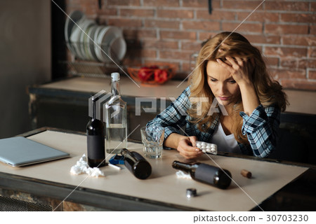 Sad woman leaning her head on left hand Sad woman leaning her head on left hand 30703230