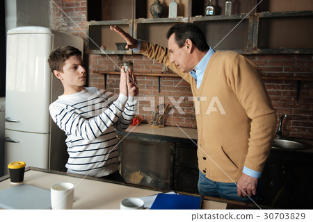 Angry father lifting his arm with on his son 30703829