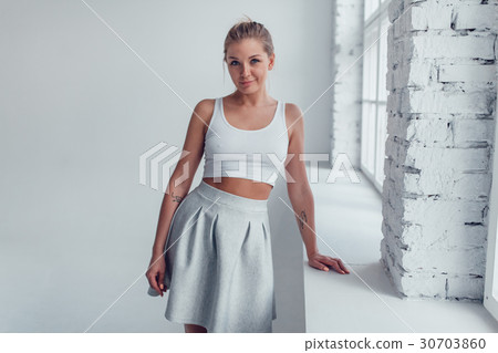 An attractive blonde woman in a white top and a An attractive blonde woman in a white top and a 30703860