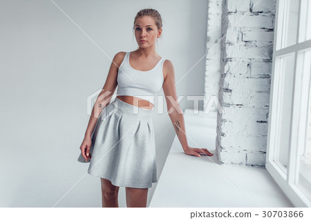 An attractive blonde woman in a white top and a An attractive blonde woman in a white top and a 30703866