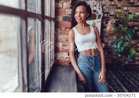 Beautiful african girl in white top standing near 30704271