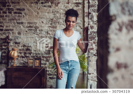 Beautiful african girl in white t-shirt standing 30704319