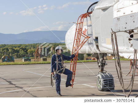 Military pilot in helmet stands near jet plane Military pilot in helmet stands near jet plane 30705141