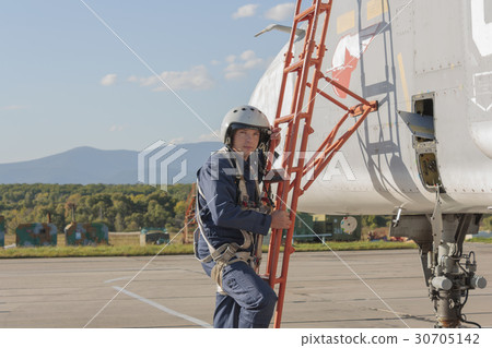 Military pilot in helmet stands near jet plane Military pilot in helmet stands near jet plane 30705142