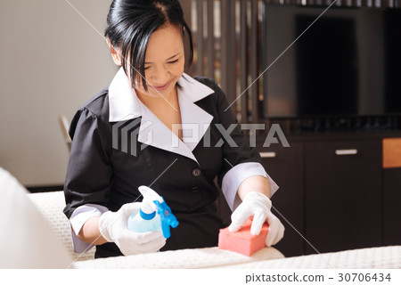 Joyful nice hotel maid doing the room cleaning Joyful nice hotel maid doing the room cleaning 30706434