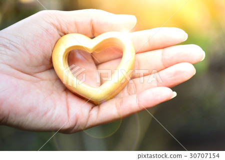 Valentines day Hands of person holding wood heart 30707154