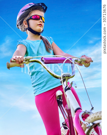 Child traveling bicycle in rainbow goggles and 30713676