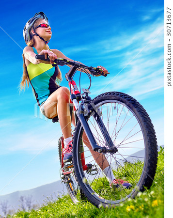 Woman traveling bicycle on green grass in summer 30713677