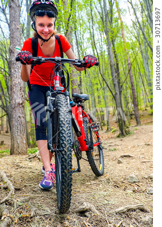 Bikes cycling girl into park. Girl wearing helmet Bikes cycling girl into park. Girl wearing helmet 30713697