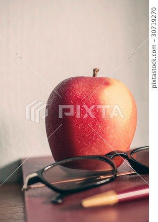 Apple on old book. 30719270