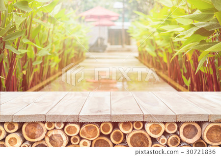 Empty top of wooden table or counter with pile wood log and sunny abstract blurred bokeh background Empty top of wooden table or counter with pile wood log and sunny abstract blurred bokeh background 30721836