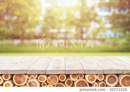 Empty top of wooden table or counter with pile wood log and sunny abstract blurred bokeh background Empty top of wooden table or counter with pile wood log and sunny abstract blurred bokeh background 30721838