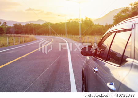 Back side of new silver SUV car parking on the asphalt road in sunset time Back side of new silver SUV car parking on the asphalt road in sunset time 30722388